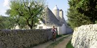 Cycling past a traditional styled trulli house in Puglia