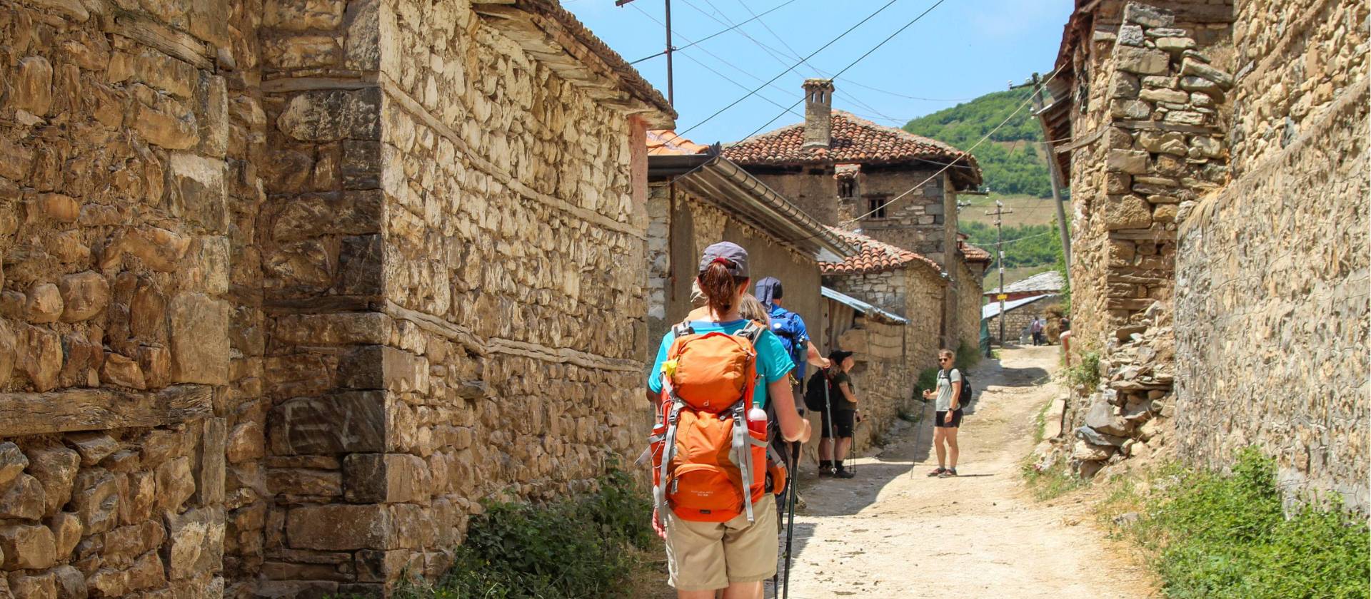 Hiking through a village on the Peaks of the Balkans Trail