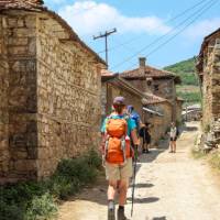 Hiking through a village on the Peaks of the Balkans Trail