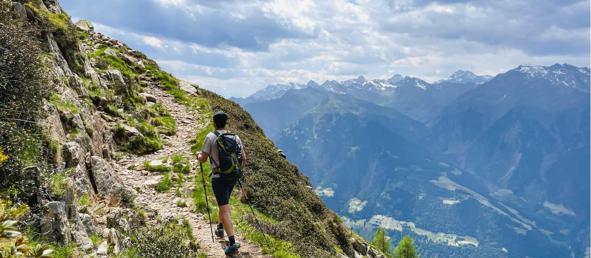 Hiker on the Passeier Valley trail beneath the peaks of South Tyrol