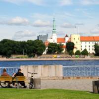 Cyclists admiring Riga Castle in Latvia