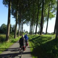 Bike and barge cyclists approaching a windmill in Belgium