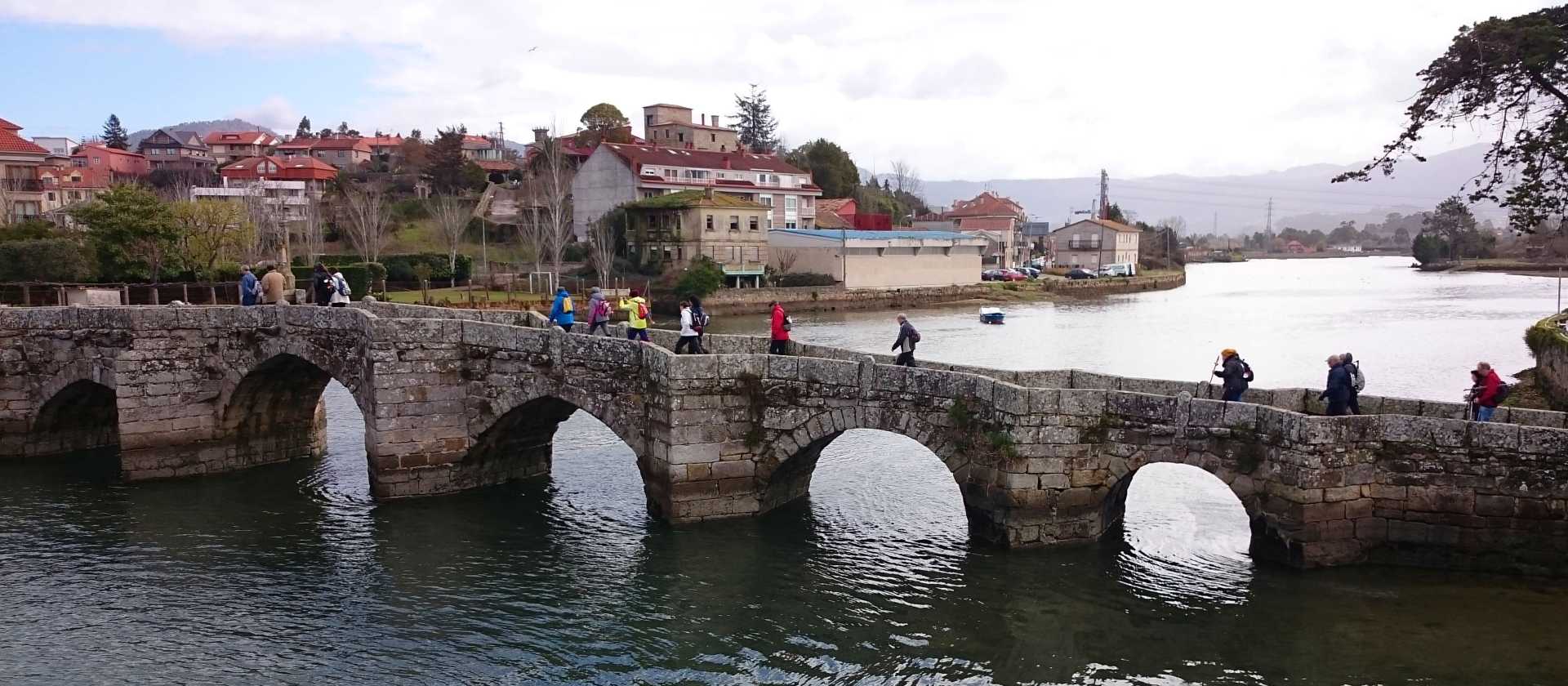 Pilgrims crossing a bridge along the Portuguese Way
