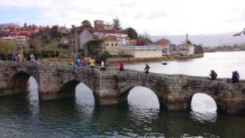 Pilgrims crossing a bridge along the Portuguese Way
