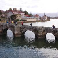 Pilgrims crossing a bridge along the Portuguese Way