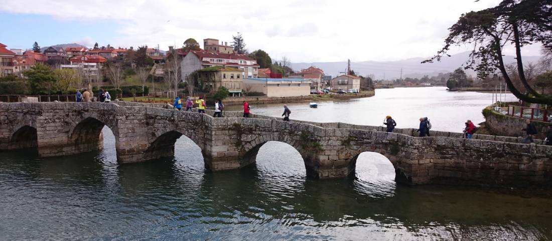Pilgrims crossing a bridge along the Portuguese Way