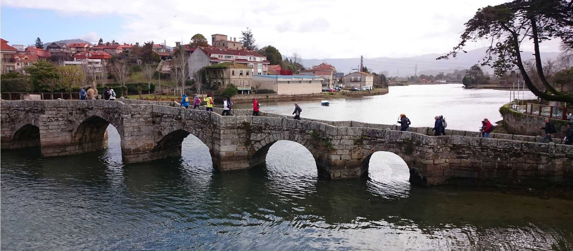 Pilgrims crossing a bridge along the Portuguese Way