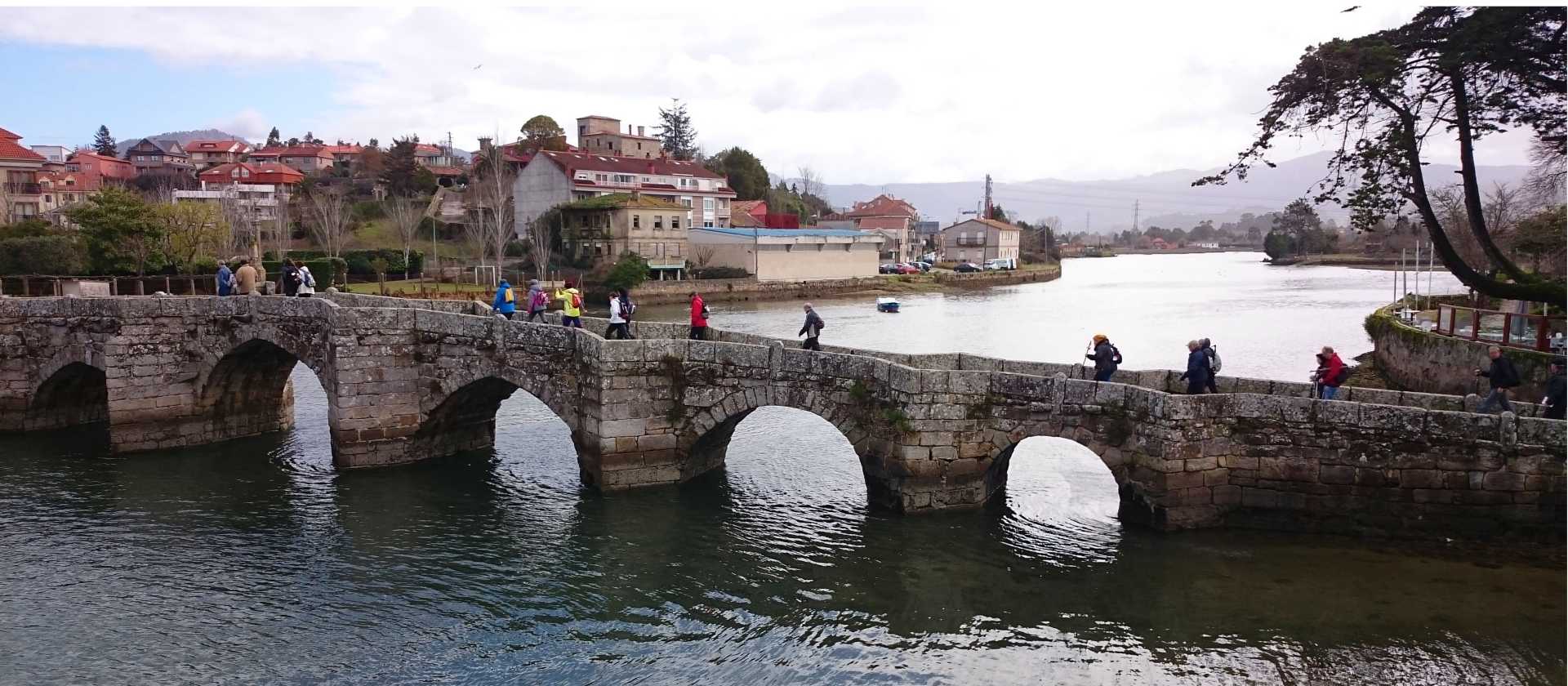Pilgrims crossing a bridge along the Portuguese Way