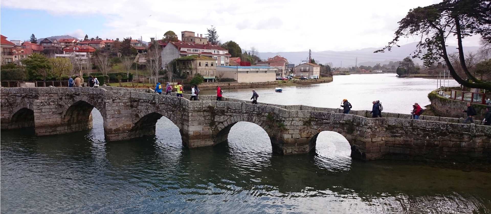 Pilgrims crossing a bridge along the Portuguese Way