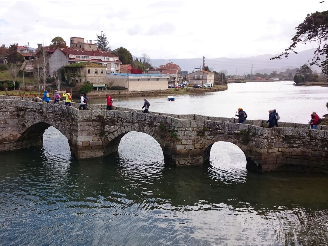 Pilgrims crossing a bridge along the Portuguese Way