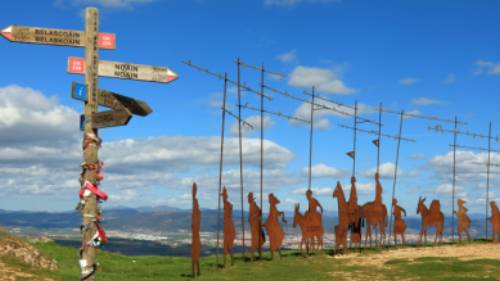 Find the iconic Alto del Perdon Camino art near Pamplona