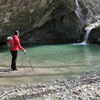 Hiker at a small waterfall on the trail from Hum to Buzet