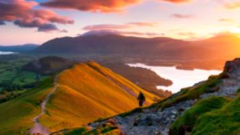 A hiker admiring the breathtaking views along the Cumbria Way.