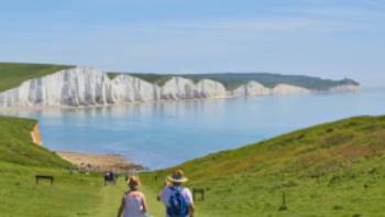 A couple walking towards the Seven Sisters on the South Downs Way