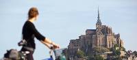 Young woman on a bike admiring Mont Saint Michel | Pierre Torset