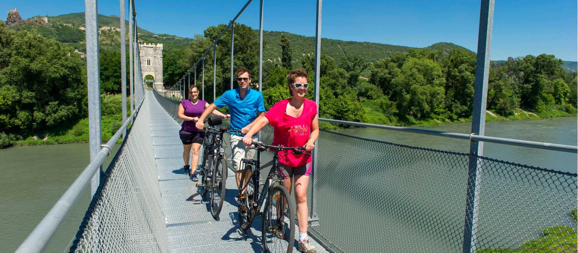 Cyclists crossing the Passerelle Himalayenne, the suspension bridge at Rochemaure enroute to Orange