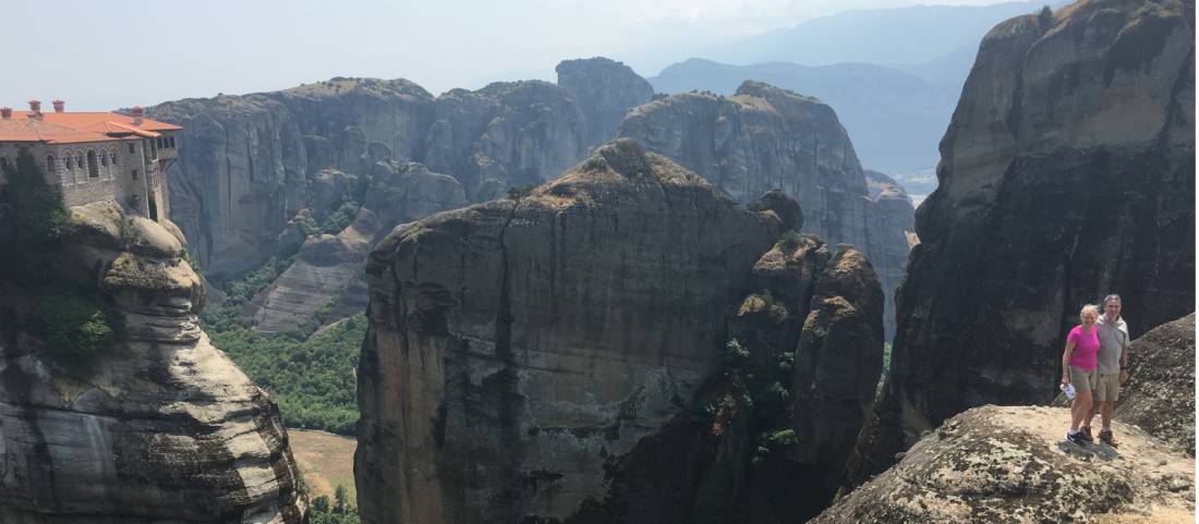 Hikers above a precipitous ridge overlooking Varlaam Monastery in Meteora |  <i>Kate Baker</i>