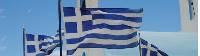 Greek flags flying above a white washed church in the Peloponnese