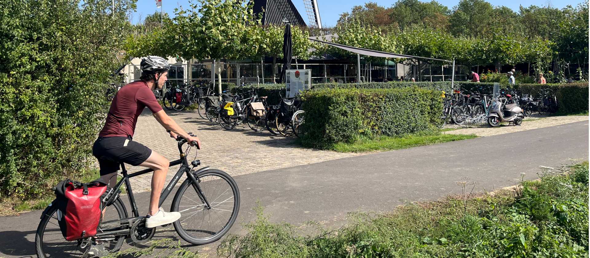Cycling the Pieterpad trail past a traditional Dutch windmill in the Netherlands.