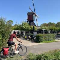 Cycling the Pieterpad trail past a traditional Dutch windmill in the Netherlands.