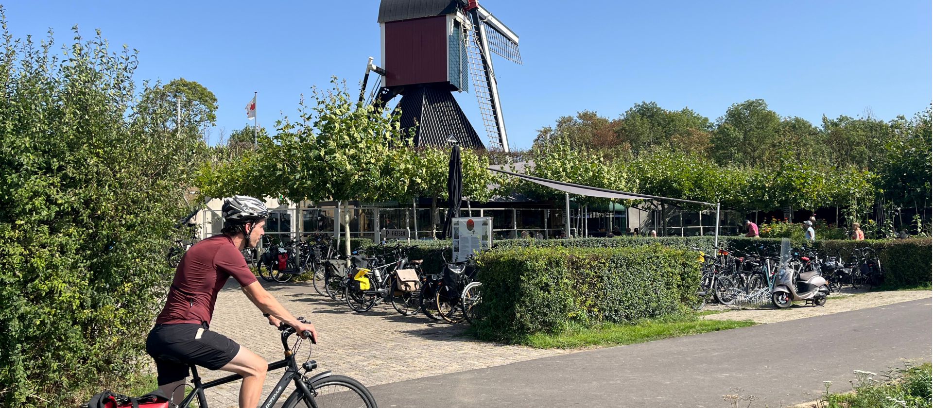Cycling the Pieterpad trail past a traditional Dutch windmill in the Netherlands.