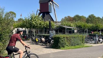 Cycling the Pieterpad trail past a traditional Dutch windmill in the Netherlands.
