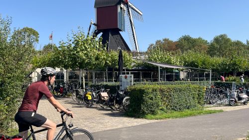Cycling the Pieterpad trail past a traditional Dutch windmill in the Netherlands.