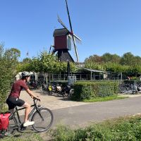 Cycling the Pieterpad trail past a traditional Dutch windmill in the Netherlands.