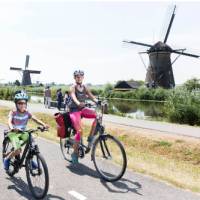 Family cycling past the windmills at Kinderdijk | Inge van Mill