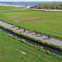 Cyclists enjoying the flat polder landscape of northern Holland