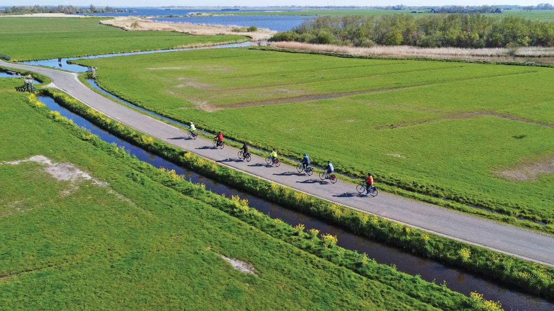 Cyclists enjoying the flat polder landscape of northern Holland