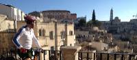 Cyclist viewing the historic cave dwellings in the Sassi di Matera | Kate Baker