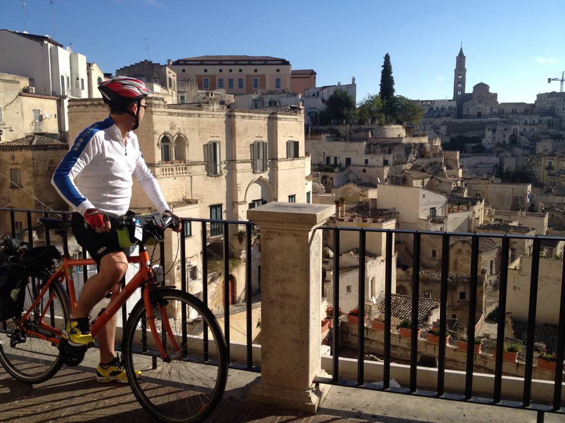 Cyclist viewing the historic cave dwellings in the Sassi di Matera |  <i>Kate Baker</i>