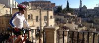 Cyclist viewing the historic cave dwellings in the Sassi di Matera | Kate Baker