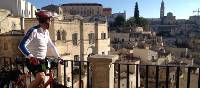 Cyclist viewing the historic cave dwellings in the Sassi di Matera |  <i>Kate Baker</i>