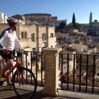 Cyclist viewing the historic cave dwellings in the Sassi di Matera | Kate Baker