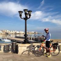 Cyclist on waterfront in Otranto | Kate Baker