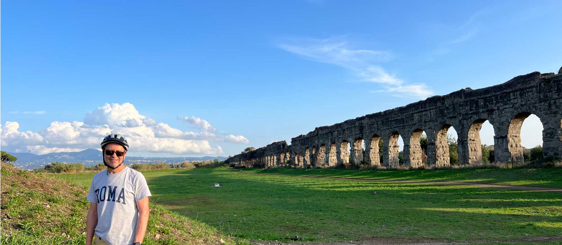 cyclist taking in the expanse of the Roman Aqueduct system | Kate Baker
