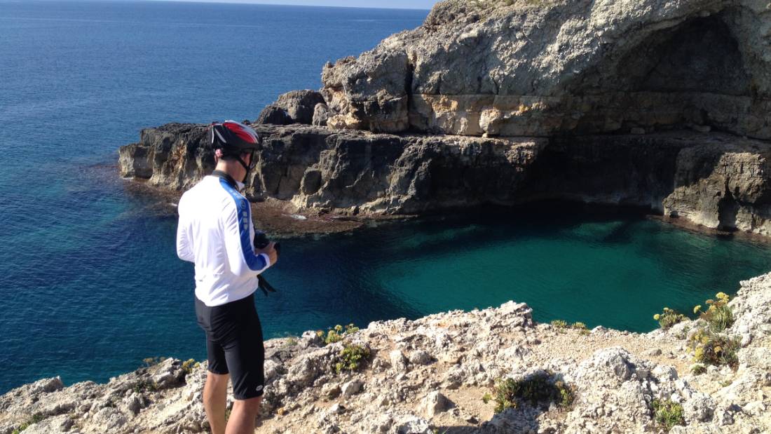Cyclist looking at the Grotto Diavolo at the heel of Italy |  <i>Kate Baker</i>