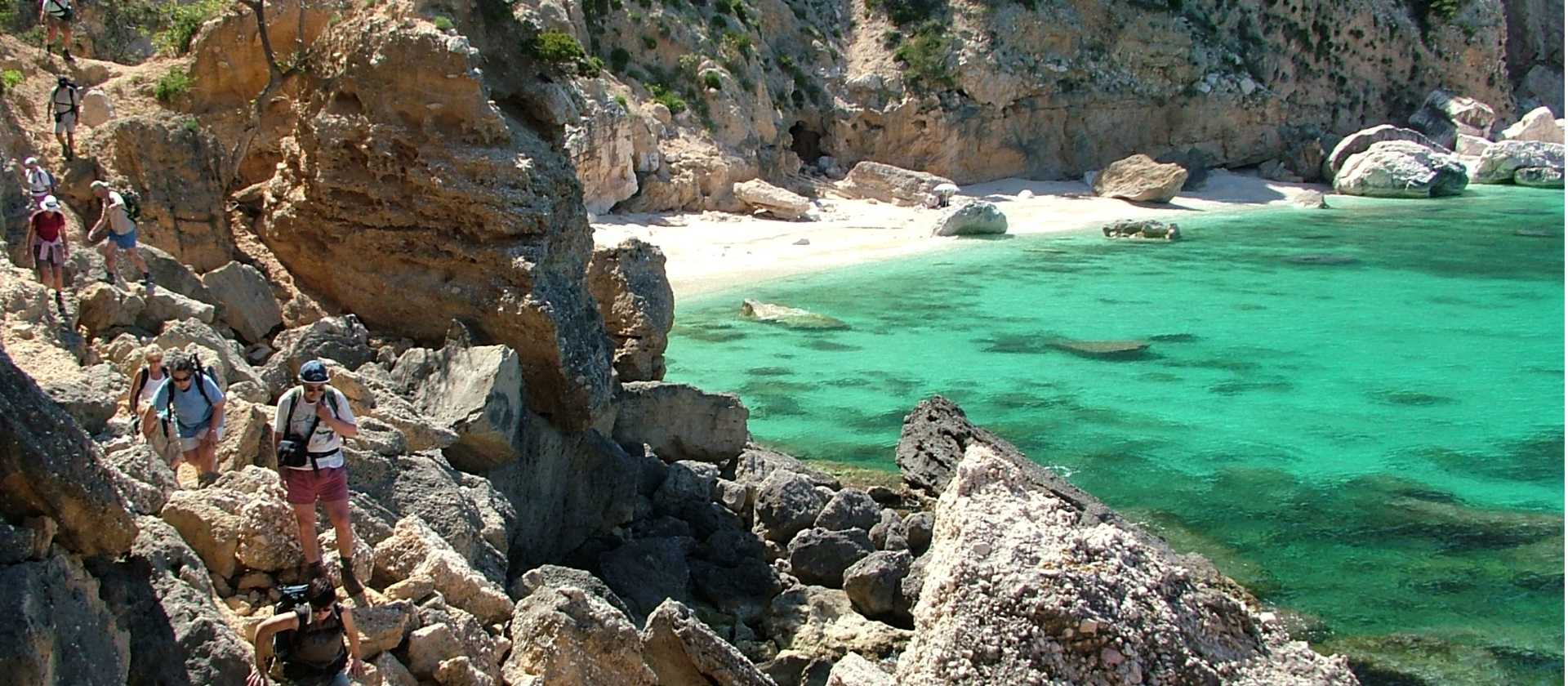 Hiker ascending from a beach in Sardinia