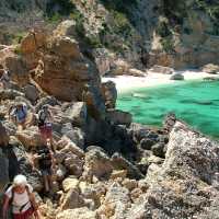 Hiker ascending from a beach in Sardinia