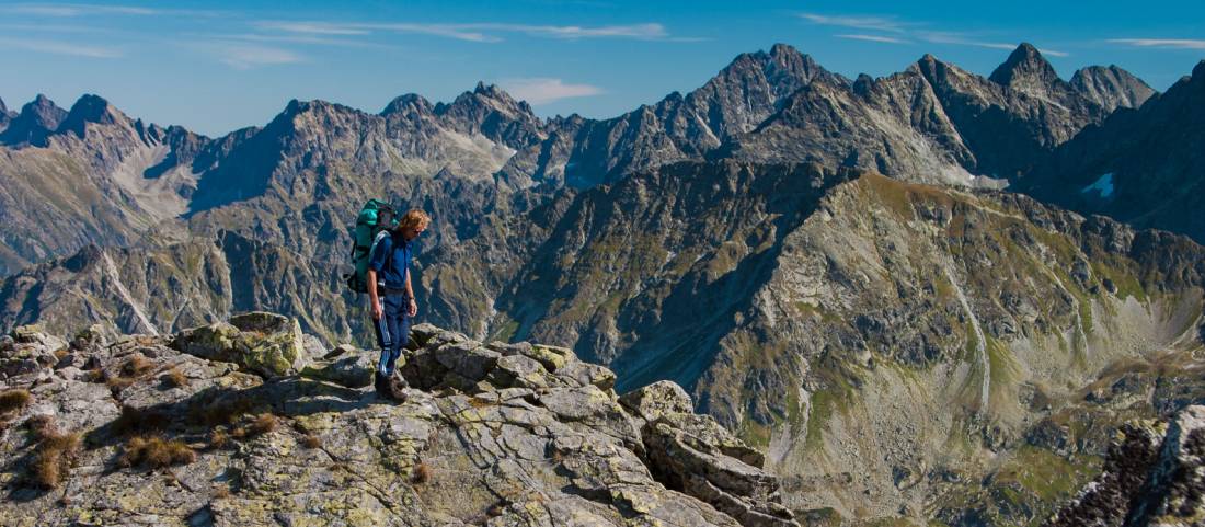 A hiker taking in the breathtaking views of the Tatra Mountain range.