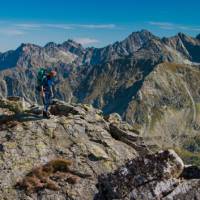 A hiker taking in the breathtaking views of the Tatra Mountain range.
