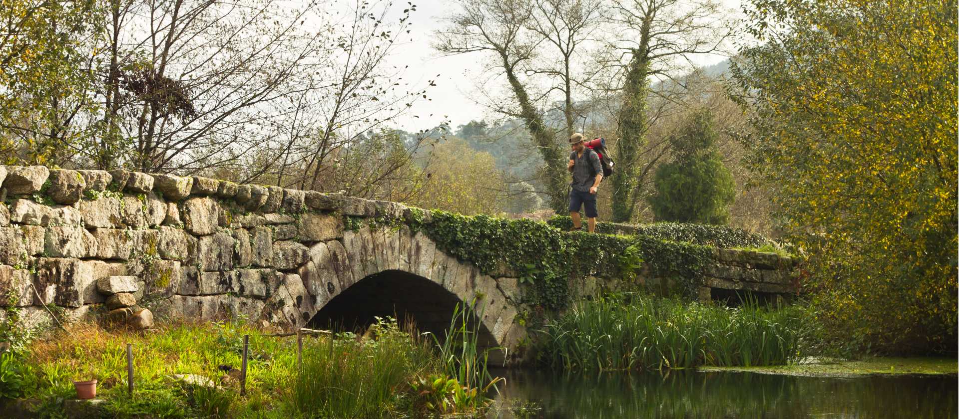 A pilgrim crosses an ancient bridge over the Neiva River in Portugal | Miguel Da Santa