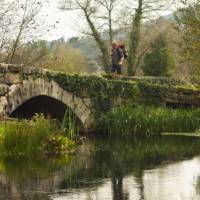 A pilgrim crosses an ancient bridge over the Neiva River in Portugal | Miguel Da Santa