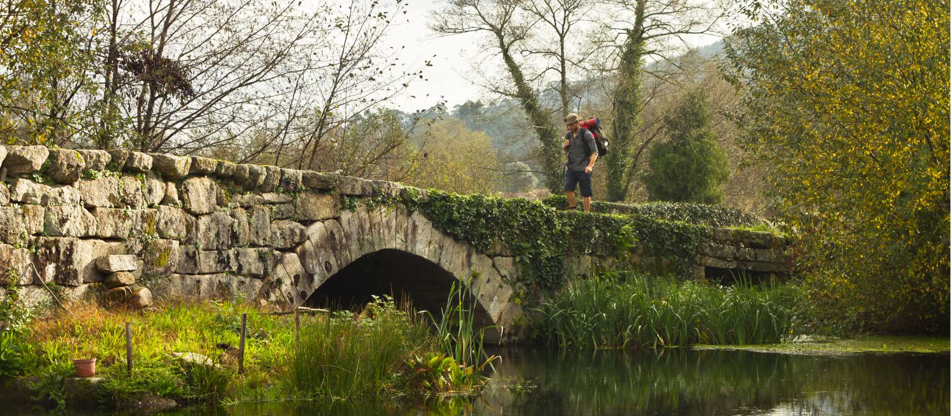A pilgrim crosses an ancient bridge over the Neiva River in Portugal | Miguel Da Santa