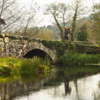 A pilgrim crosses an ancient bridge over the Neiva River in Portugal | Miguel Da Santa