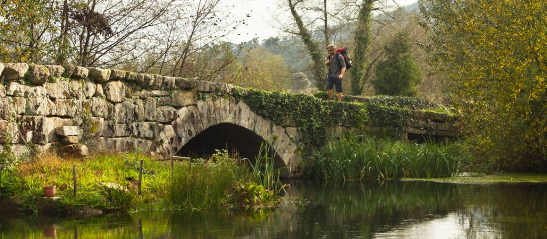 A pilgrim crosses an ancient bridge over the Neiva River in Portugal |  <i>Miguel Da Santa</i>