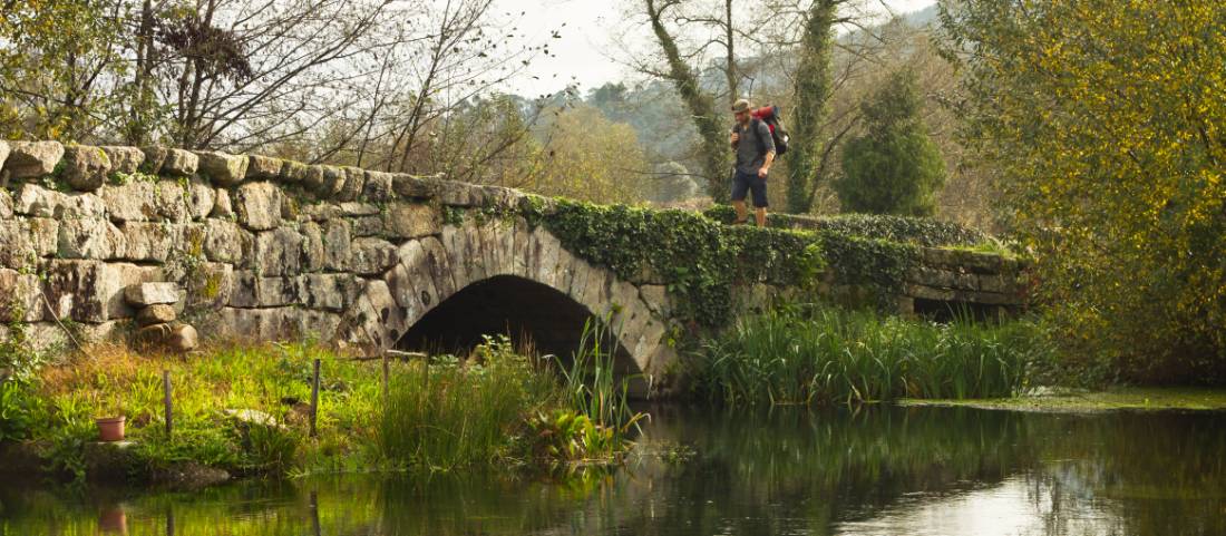 A pilgrim crosses an ancient bridge over the Neiva River in Portugal |  <i>Miguel Da Santa</i>