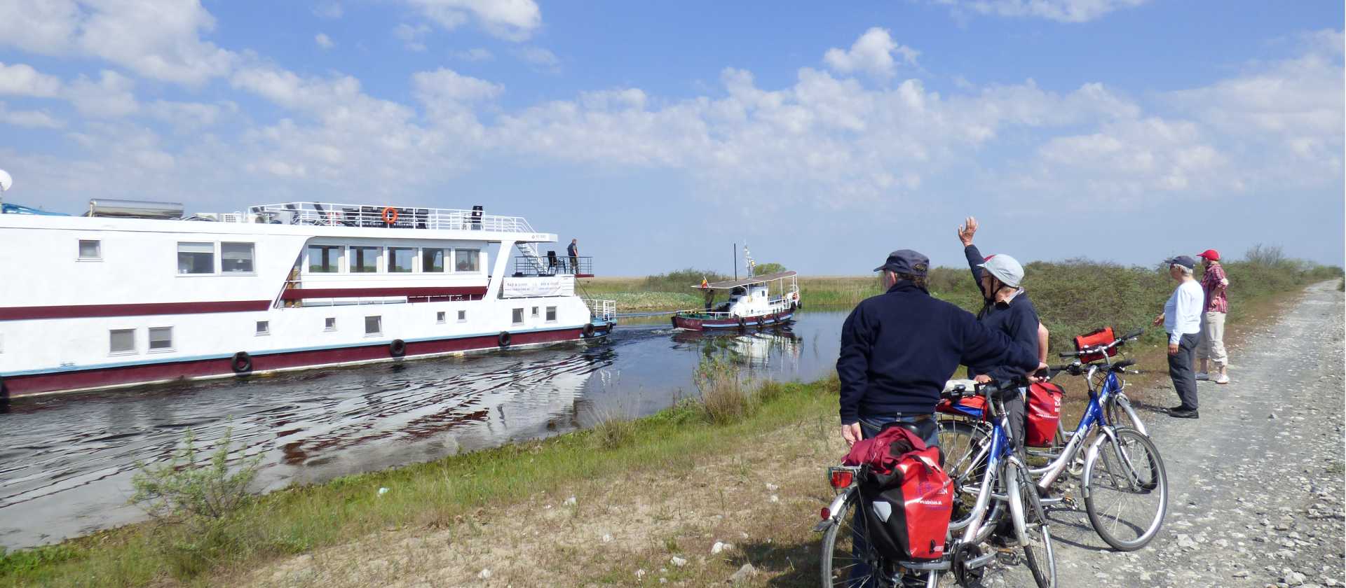 Cyclists watching the boat on the Danube Delta